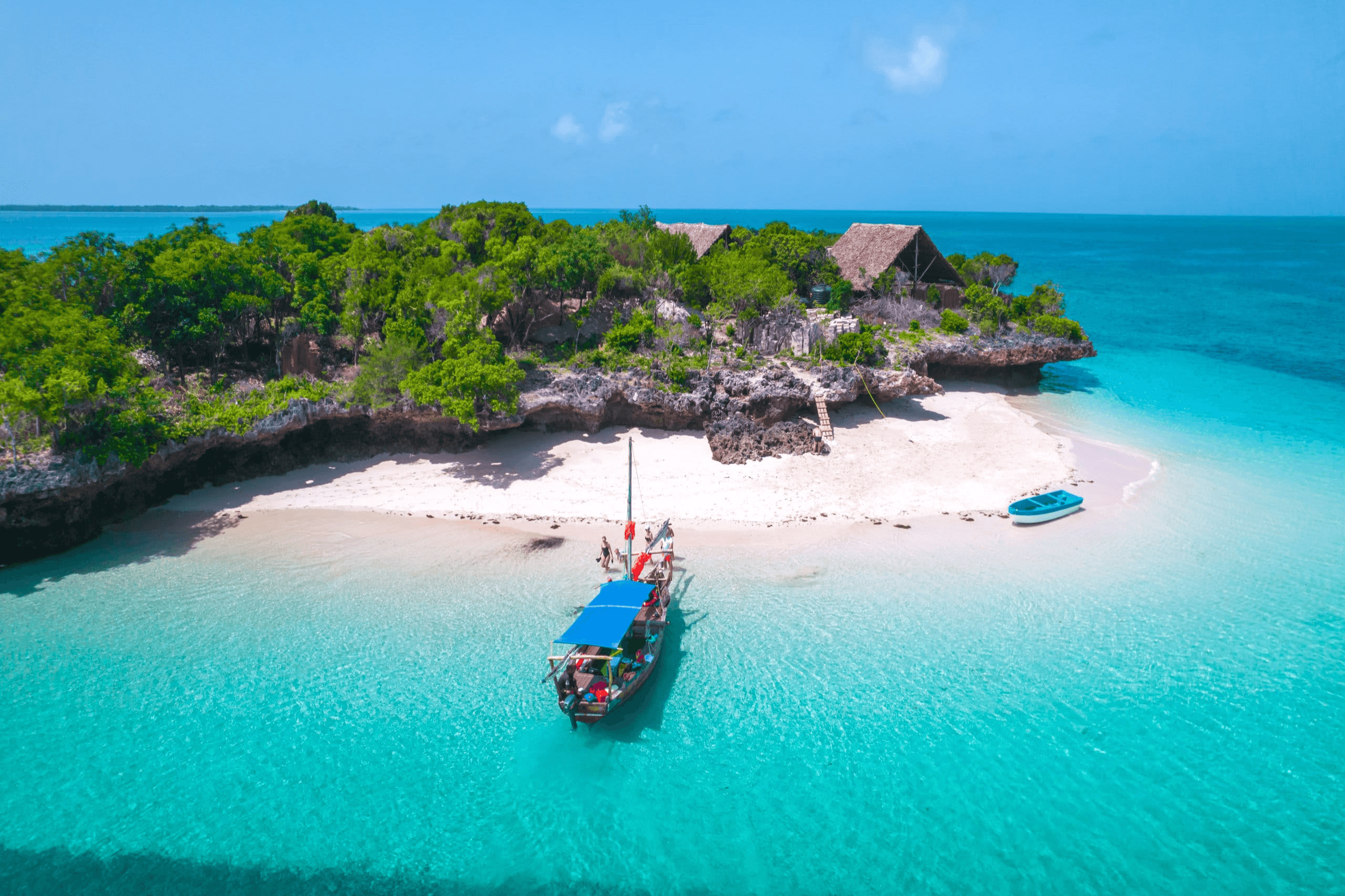Zanzibar beach with turquoise water and boats for guest activities